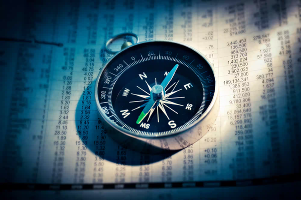 Image d'une boussole sur des papiers financiers